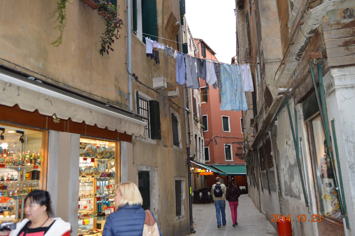 День третий! Как хорошо не работать, но как плохо, когда не работают другие! Утро третьего дня встретило нас солнышком. Когда мы открыли ставни, оно уже почти встало, и на душе было легко и приятно. Кстати, все отели, в которых мы останавливались, на окнах имеют ставни, что очень удобно, учитывая то, что по-моему, в Италии всегда и везде горит свет и они вообще спать не ложатся, такое создалось впечатление. А еще показалось, что они постоянно друг с другом ругаются... Но это мне только показалась, наверное они просто жутко темпераментные. Ну так вот, то прекрасное утро, я начала с осваивания техники заваривания кофе по-итальянски:))) так хозяин гостиницы, выдав нам накануне ключи, сказал берите что надо на кухне, будете уходить, ключи оставьте в номере. Но я не предполагала, что он просто будет храпеть на всю гостиницу, пока мы будем сами готовить оплаченный заранее завтрак:)) хозяин живет тут же, и особо по поводу завтрака видимо вообще не парится! Странное сооружение, видимо служащее в Италии кофейником, я конечно покрутила, долго пытаясь понять технологию заваривания кофе в нем. Даже нашла, куда засыпается кофе... Но дальше дело застопорилось. Мы с Женечкой разошлись во мнениях, в какую часть этой конструкции наливать воду... В итоге, мы плюнули на это дело, бросили в сумку пару круассанов, наскоро приняли бодрящий душик и решили, что выпьем кофе по дороге. Выйдя из гостиницы, мы выбрали кофейню, где пили кофе местные, и насладившись утренним капуччино и отличным теплым и солнечным утром, пошли искать станцию парома. До поезда на Милан, у нас было еще достаточно времени, поэтому мы шли, любуясь утренней Венецией, которая была поистине великолепна, делясь впечатлениями и планами на день. Вообще, я давно заметила, что самый длинный путь, начинается со слов, ПОШЛИ, Я ЗНАЮ КОРОТКУЮ ДОРОГУ!!! Короче, через какое-то время, уже порядком подустав, мы вышли наконец в Гранд каналу, правда через две станции от той, к которой стремились, но не суть:) нашли же. Перешли мостик, подошли к станции, а там как-то подозрительно тихо, билетная касса закрыта, какая-то подозрительная тишина. Мы спросили у дедушки, который торговал рядом газетами, что за тишина на станции, на что дедушка (добрый блин дед) сказал, ЭТА СТАНЦИЯ ЗАКРЫТА, вы дойдите вон до той.... Ладно, время есть, мы дойдем!!!! В то прекрасное, солнечное утро, мы носились по Венеции с чемоданами, от станции к станции... Прошли в общей сложности 4 км, и учитывая то, что каждые 300 метров на пути были мостики со ступеньками, это было равнозначно хорошей тренировке. Но наконец мы добрались обратно, к площади Сан Марко и вот там на станции было оживленно, туристы с чемоданами бегали довольные по причалам, но кассы не работали!!! Тут бы нам, как жителям России, насторожиться... Но нет, мы же в Италии, Европа, цивилизация!!! Мы купили билеты на паром в автомате... И тут выяснилось, что паромы в ближайшие 24 часа не работают!!! ........ Дальше следует непереводимая игра слов, которые приводить я тут не буду, меня мама хорошо воспитала... Мы так и не выяснили, против чего и почему они бастовали, но все туристы, которые стояли на причале, с купленными билетами, в тот момент дружно любили сотрудников паромов, желали здоровья им и всем их родственникам до седьмого колена!!!!!! Вот и мы, стояли с чемоданами на причале, зажав в руке билет на паром, когда наш поезд, благополучно отошел от перрона, в сторону Милана, без нас!!!