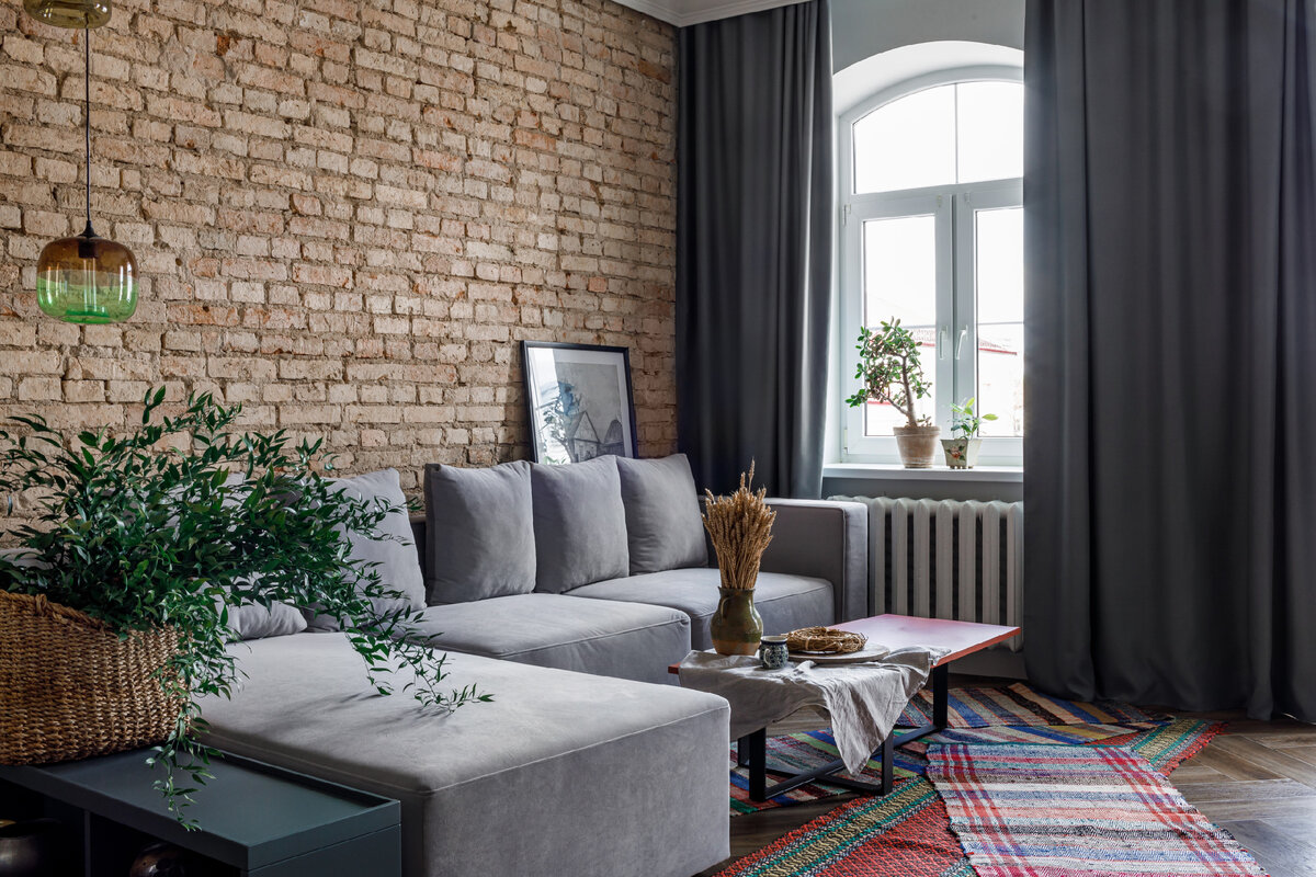 Особую изюминку интерьеру придает традиционный этно-декор — кружевная салфетка на телевизоре, старые книги, самотканые ковры, плетёные корзины, керамика и колосья пшеницы.