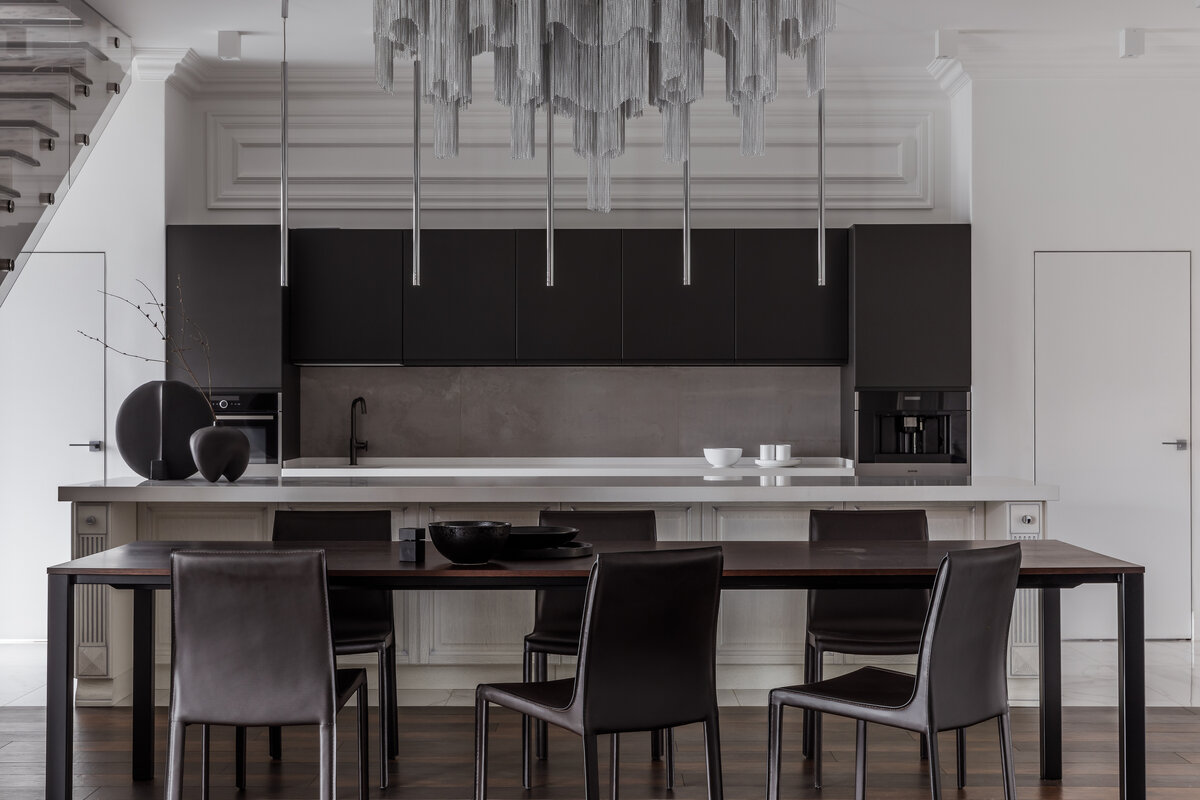 Журнальный стол со столешницей из кварцевого агломерата гармонирует с керамогранитом в зоне кухни.