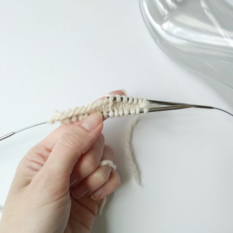 Провяжите 2 ряда (изн. и лицевой). С лиц.стороны наберите другой спицей или круговыми спицами столько же петель с передних наборных петель