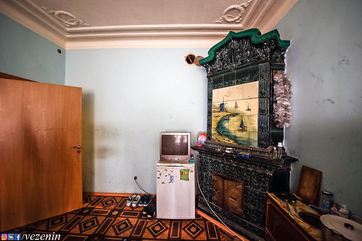 Холодильник, телевизор, двери и линолеум добавляют некоего шарма дореволюционному декору.