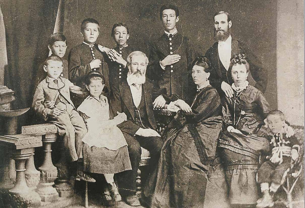 Семья Чеховых. Сидят (слева направо): брат писателя Михаил, сестра Мария, отец Павел Егорович, мать Евгения Яковлевна, жена дяди Митрофана Егоровича Людмила Павловна, их сын Георгий; стоят: брат писателя Иван, Антон, старшие братья, Николай, Александр, дядя Митрофан Егорович. Таганрог. 1874 год