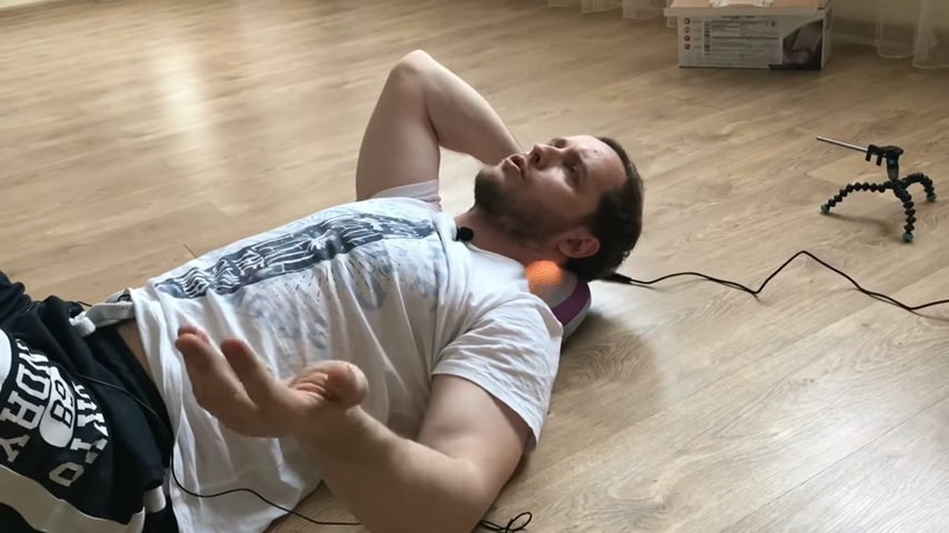 Епифанов массажирует шею этой подушкой.