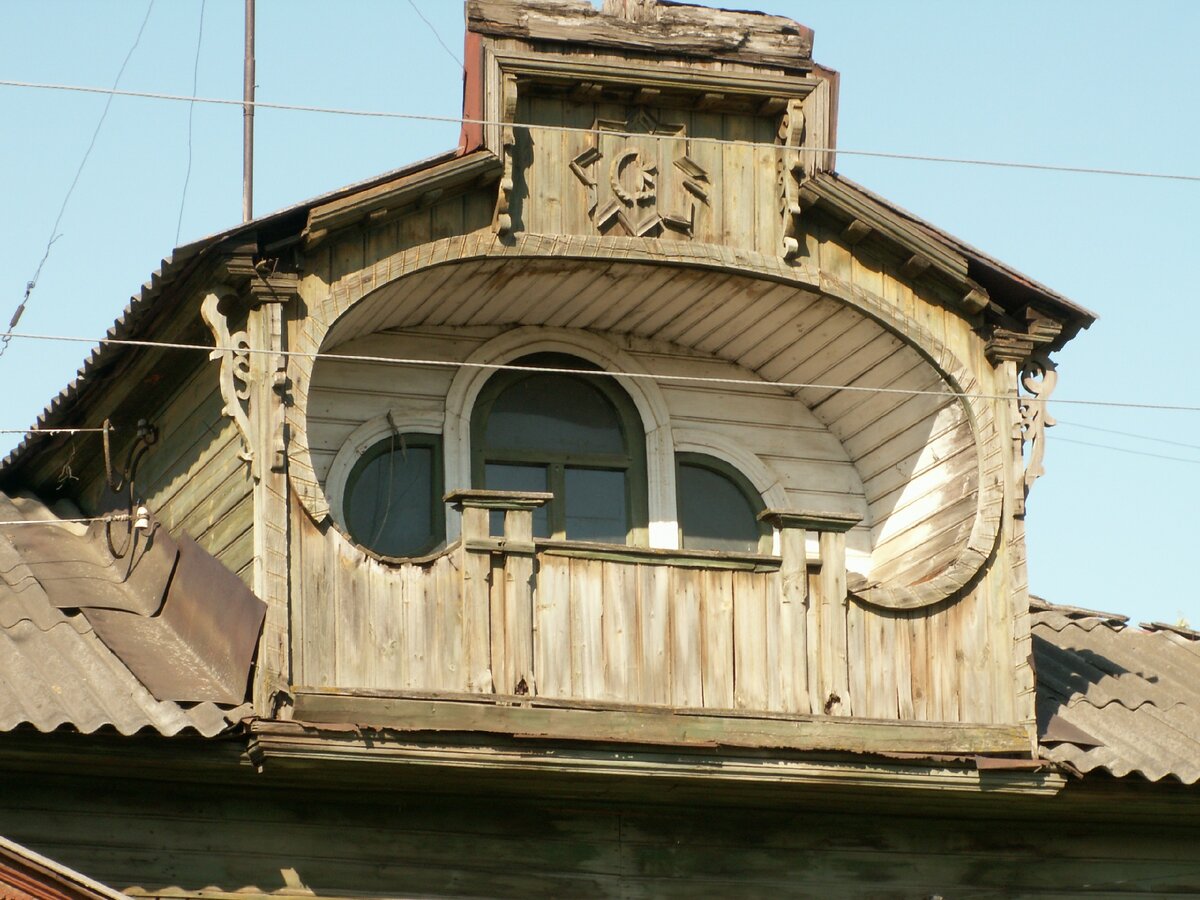 Такой затейливый декоративный балкончик под крышей, вероятно, с инициалами хозяев по центру