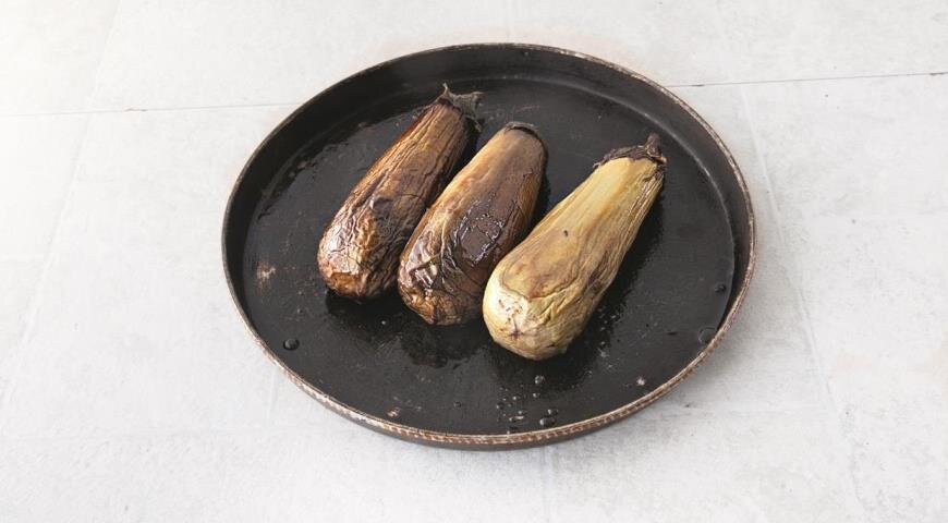 Разогрейте духовку до 200 °С. Очистите баклажаны от кожицы, но не удаляйте черешки. Положите на решетку и запеките до мягкости, 20 мин. Остудите.