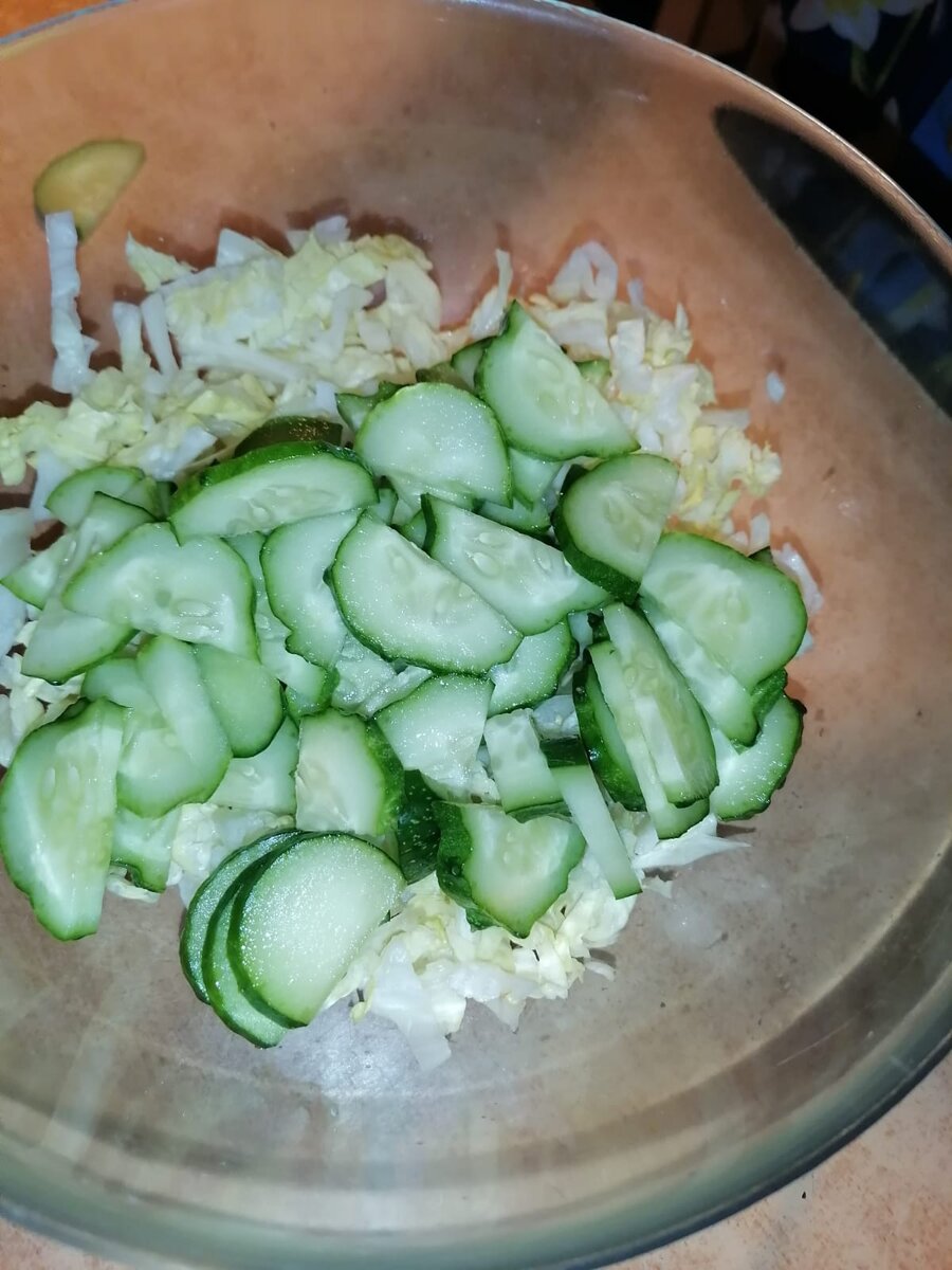 В глубокую миску закидываем уже нарезанный салат Айсберг, огурцы