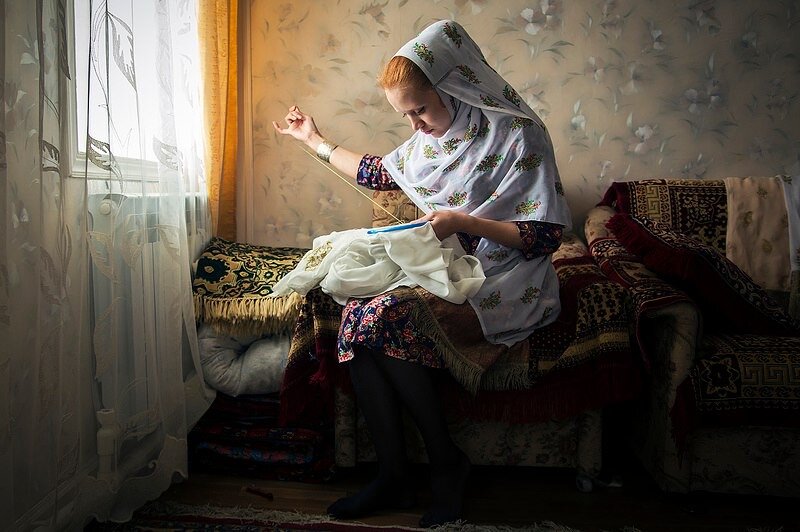 Тайна кубачинского Каза
Кубачинские женщины носят особенные платки, по которым их легко узнать с первого взгляда, — казы. Мы расспросили сельчанок о секретах этого необычного головного убора, и вот что они нам рассказали. 

Секрет первый. Откуда взялся каз? 
Каз представляет собой белую ткань, расшитую узорами из золотой нити и украшенную бахромой. Строго говоря, это не платок, а шарф. Но называют его все-таки платком. Такие уборы носят только женщины дагестанского села Кубачи. Больше никакой другой платок или шарф этим словом не обозначается. И больше ни в каком другом селе женщины не носят казы — только в Кубачи. Выезжая из села, кубачинки обычно снимают свой традиционный платок. Редко кто ездит в нем даже в соседнее село. В Махачкале и других городах казы можно встретить на улицах только во время официальных праздников, таких как День единства народов, день Конституции Дагестана, празднование 2000-летия Дербента. В эти дни многие дагестанцы надевают национальные костюмы. Сколько лет казам и откуда именно в этом селе взялась традиция носить этот платок, точно неизвестно. Местные жители говорят, что казам столько же лет, сколько и селу. А это примерно 15 веков. 

Секрет второй. Матримониальный Каз 
— это не просто головной убор, расшитый золотыми нитками. По рисунку на платке определяется статус девушки: замужем она или нет. Чаще всего кубачинки вышивают на своих платках цветы или перья. Но узор на платке незамужней девушки мелкий, а замужняя носит каз с крупным рисунком. Отличается также длина бахромы: на платке незамужней женщины она короче, чем на платке замужней. В обычном казе бахрому пришивают только на один конец. Раньше женщины надевали под каз чохто — дагестанский женский головной убор (напоминает матерчатую продолговатую трубу; в нее женщины прятали волосы). Сейчас его носят не все, обычно каз сразу накидывают на волосы. 

Секрет третий. Траурный 
Если кто-то умирает, кубачинские женщины не надевают черные одежды. О том, что кубачинка в трауре, можно узнать по казу: на нем не будет бахромы и яркого узора. Бахрому снимают на 40 дней либо на год — в зависимости от того, насколько близкий родственник умер. Когда траур окончен, бахрому пришивают снова. 

Секрет четвертый. В цифрах 
Современные кубачинки говорят, что покупают хлопчатобумажную ткань на каз у местного бизнесмена, который привозит ее из арабских стран. Стоимость отреза на каз — 1000 рублей. В советское время казы были из маркизета, но этот материал быстро мнется, а со временем желтеет, и платок теряет свой вид. Стандартная длина каза — 2,5 метра (без учета бахромы), ширина — 50−70 см. Если женщина невысокая, платок можно немного укоротить, но так, чтобы это не бросалось в глаза. 

Секрет пятый. Ручной работы 
В Кубачи каждая женщина с детства учится вышивать каз. Старшие женщины в семье (сестры, мамы, тети, бабушки) учат этому девочек еще с дошкольного возраста. Порой малышка еще не умеет читать и писать, но уже уверенно держит в руках иголку. Правда, носить каз они начинают гораздо позже — в 15−16 лет. Носят и дома, и на улице, и в школе, но все это по желанию, без «обязаловки». А с недавних пор в селе появилась новая традиция: 1 сентября одиннадцатиклассницы обязательно надевают каз в школу. Современные кубачинки нередко вышивают узор на казе швейной машинкой. — А бабушки не ворчат, что молодежь совсем обленилась, не хочет тратить время на ручную работу? — Так получается быстрее и зрение не портится, — объясняют женщины нововведение. Носить каз с машинной вышивкой зазорным не считается. Просто такой платок значительно падает в цене: его стоимость будет примерно 2−3 тысячи рублей. Современные кубачинки чаще вышивают узор на казе швейной машинкой Стоимость каза с узором ручной работы зависит от нескольких моментов: насколько мелкая вышивка (чем мельче, тем дороже), «возраст» нити и бахромы, сколько времени заняла работа над платком. Кстати, на вышивание каза уходит от нескольких недель до года. Стоимость платка с узором ручной работы — выше 10 тысяч рублей. 

Секрет шестой. Свадебный 
Девушки в Кубачи выходят замуж в традиционной свадебной одежде. Каз невесты называется лумкитабказ Каз невесты называется лумкитабказ. От обычного он отличается тем, что бахрома у него свисает с двух концов, а не с одного, а по длинным сторонам платка пришита тесьма. Вышитого узора на свадебном казе может не быть, но тесьма — обязательна. Когда кубачинка выходит замуж, она, как правило, надевает традиционное платье и лумкитабказ, которые надевали ее пра-пра-прародственницы на свои свадьбы. Платье расшито золотыми или серебряными нитками. Со временем многие эти платья теряют свежесть и яркость. Интересуюсь: а не воротят ли нос современные модницы от старых потертых платьев? — Нет! — отвечают женщины хором. — Наоборот, с гордостью носят. Если судьба не дала дочерей, подарить свадебный наряд можно любой родственнице, выходящей замуж, либо молодой невестке. По обычаю, 40 дней после свадьбы молодая жена ходит дома и по селу в национальной одежде. 

Секрет седьмой. Наследственный 
Кубачинки сохранили традицию передавать по наследству бахрому для казов. Чем старше бахрома на платке, тем он ценнее. Потому женщины совсем не ленятся перешивать полосы с одного платка на другой. И даже сейчас в селе носят казы с бахромой, которую на своем платке носила кубачинка, жившая в XIX веке. А может, и раньше. Выдавая дочку замуж, мама обязательно должна положить в сундук с приданым казы. Их количество не ограничено: чем больше, тем лучше. Но есть незыблемое правило: в приданом обязательно должны быть два каза с рисунками, которые считаются особенными, — кацаннаказ (с цветами) и калкуссалаказ (с перьями). По словам кубачинок, это самые старинные узоры, дошедшие от их предков до наших времен, и современные девушки должны передать их своим детям. 