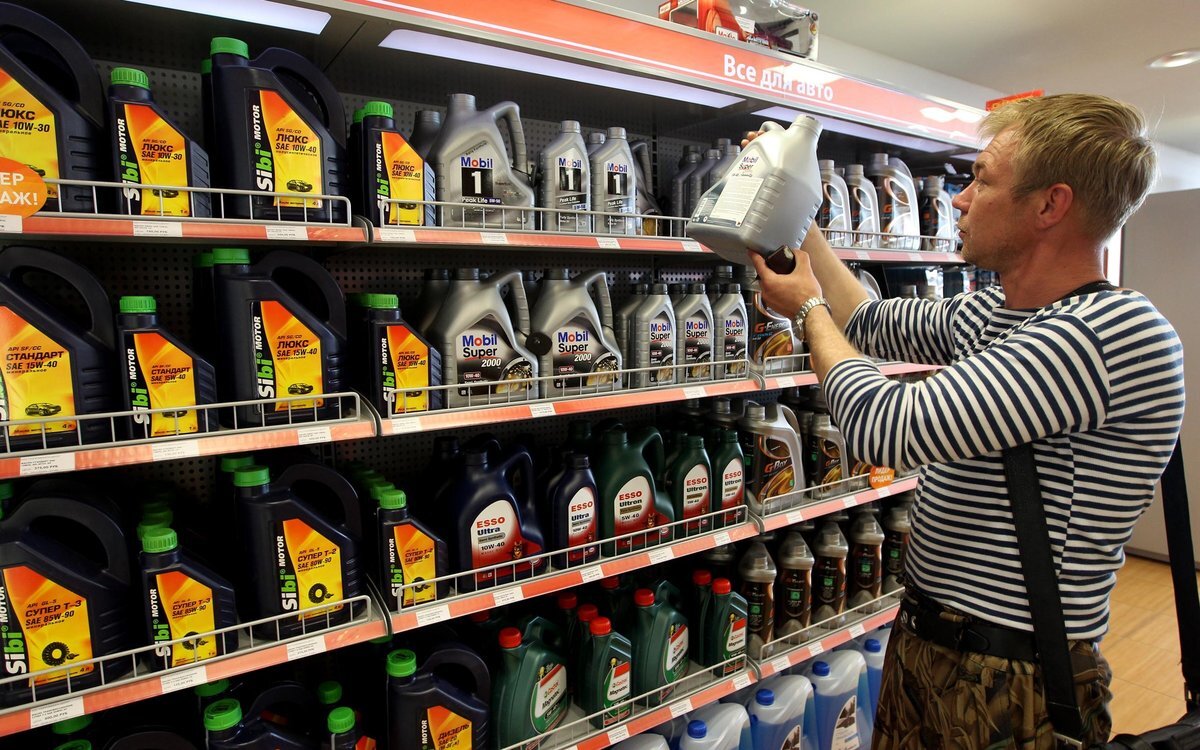 Парниша выбирает моторное масло в магазине