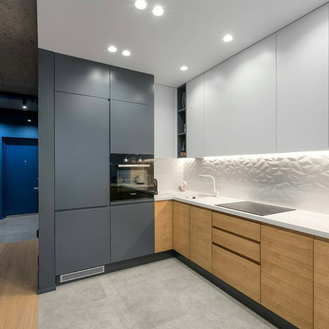 Холодильник встроен в пенал, а решётка внизу для его вентиляции.