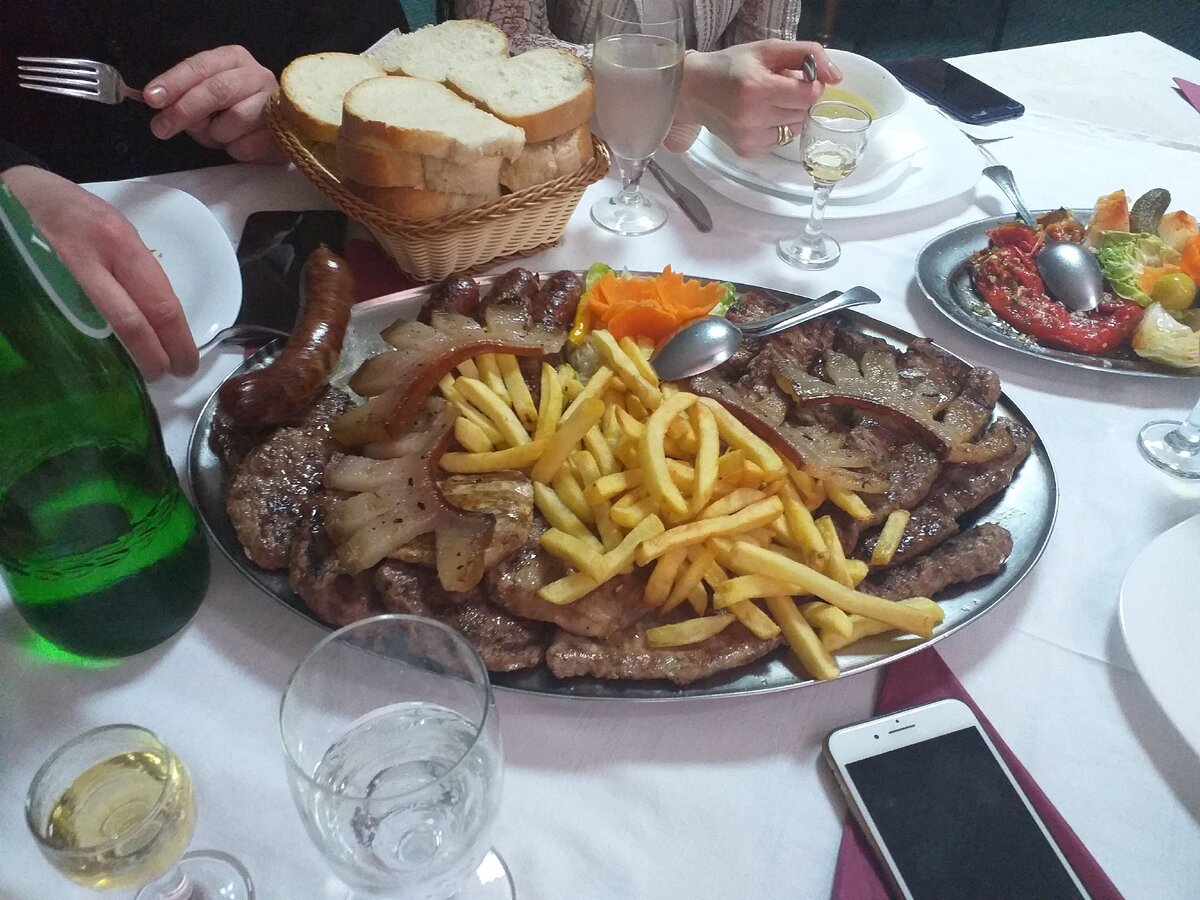 На тарелке отбивные из свинины, говяжьи колбаски, чевапчичи.