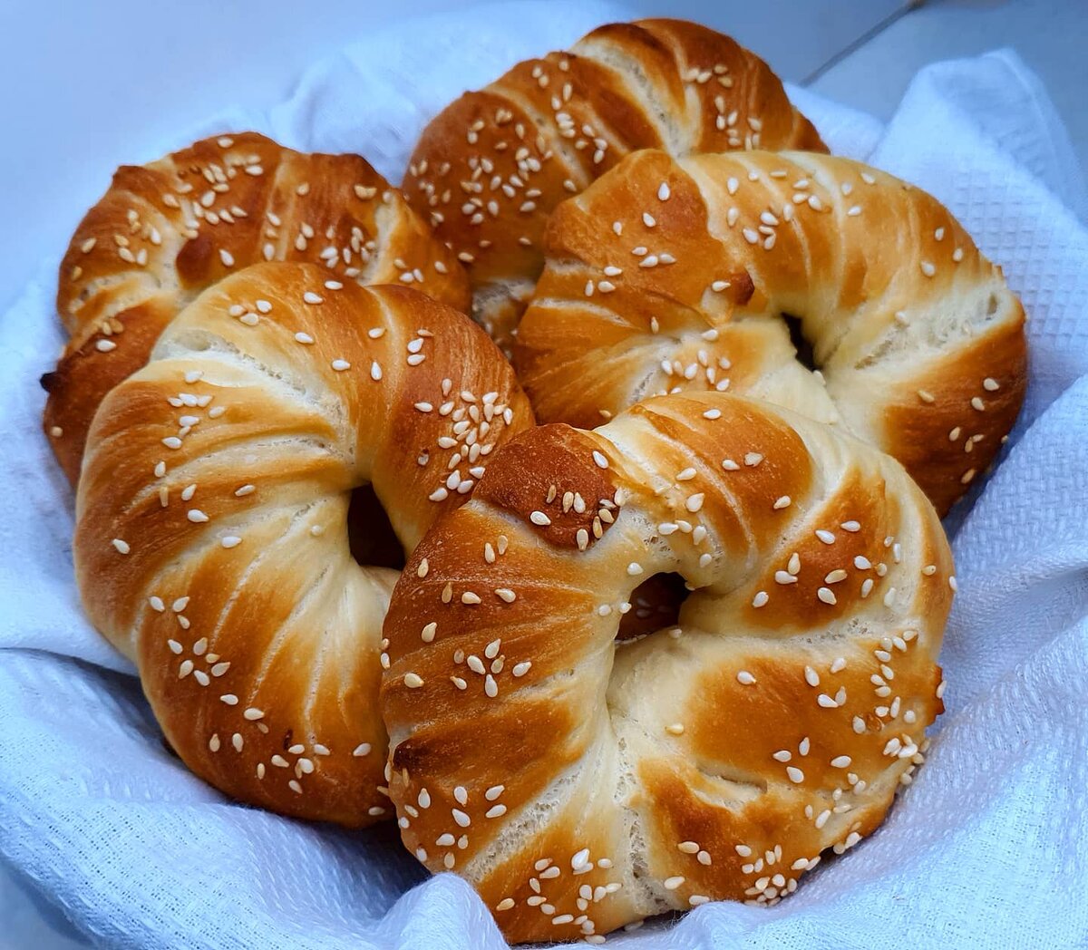 ТУРЕЦКИЕ СИМИТЫ .🥨🥨🥨 

СИМИТ - самая популярная булочка в Стамбуле, да и наверное во всей Турции. Готовится легко и просто в домашних условиях.


 воды - 200 мл
сухих дрожжей - 1 ч л
соли - 1 ч л
сахара - 1 ст л
мука - 400 гр
масла растительного - 40 мл

ДЛЯ СМАЧИВАНИЯ СИМИТОВ
вода - 200 мл
мëд - 2 ст л

В теплую воду добавляем сахар, соль, дрожжи перемешиваем и ждем пару минут ,что бы дрожжи активировались .
В одну часть просеянной муки  всыпаем и замешиваем липкое тесто далее вливаем растительное масло, добавляем оставшуюся муку и замешиваем тесто , накрываем и убираем в теплое место на 40 мин. 
Готовое тесто делим на равные 7 частей скатываем  в шарики , 
 из каждого шарика формируем цилиндры вытягиваем и начинаем скатывать в длинный жгут. Жгут складывается в двое и скручиваем его, края жгута соединяем и снова подкручиваем его , получается симит. 
Теперь наши симиты купаем , для этого берём глубокую миску смешиваемся воду и мёд, окунаем каждый симит и обваливаем в кунжуте. Пока  духовка нагревается даём постоять симитам 15 мин в теплом месте. Выпекаем при температуре 250° 20 мин до золотистого цвета.
Симиты готовы , ко столу подавать с мёдом. 

ПРИЯТНОГО АППЕТИТА!!!!!
#рецепт#турецкие#симиты#самая#популярная#булочка#Стамбула#домашний#готовимсВикой#футблогер#vladimirowna86