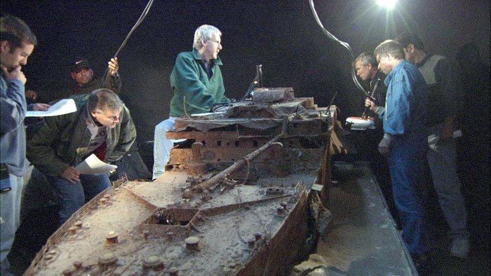 Джеймс Кэмерон и его команда изучают маршрут будущих подводных съемок на макете останков Титаника. 
