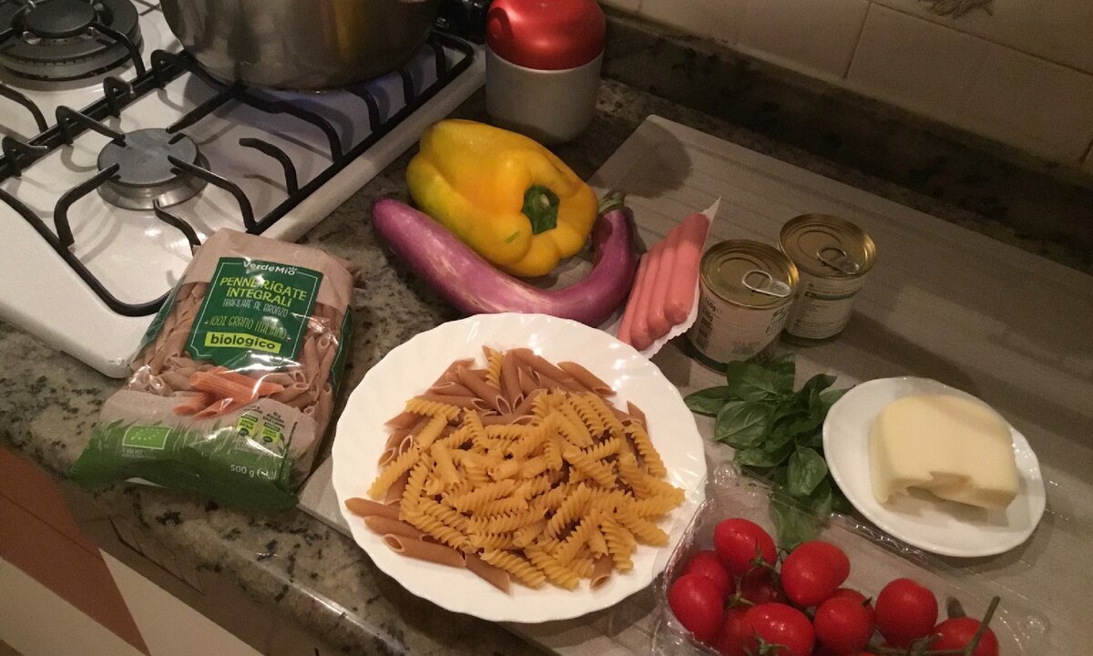 Все ингредиенты на одном фото: консервированный зелёный горошек, перец, баклажан, помидорчики, сосиски, сыр, базилик и собственно макароны