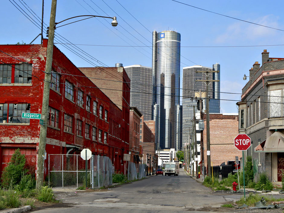 Детройт. Разрушенная почти полностью промышленность, на фоне блестящих небоскребов делового центра города. Вся промышленность загнулась, тысячи и сотни тысяч людей брошены, потому что капитал ушел и никому нет дела до людей.