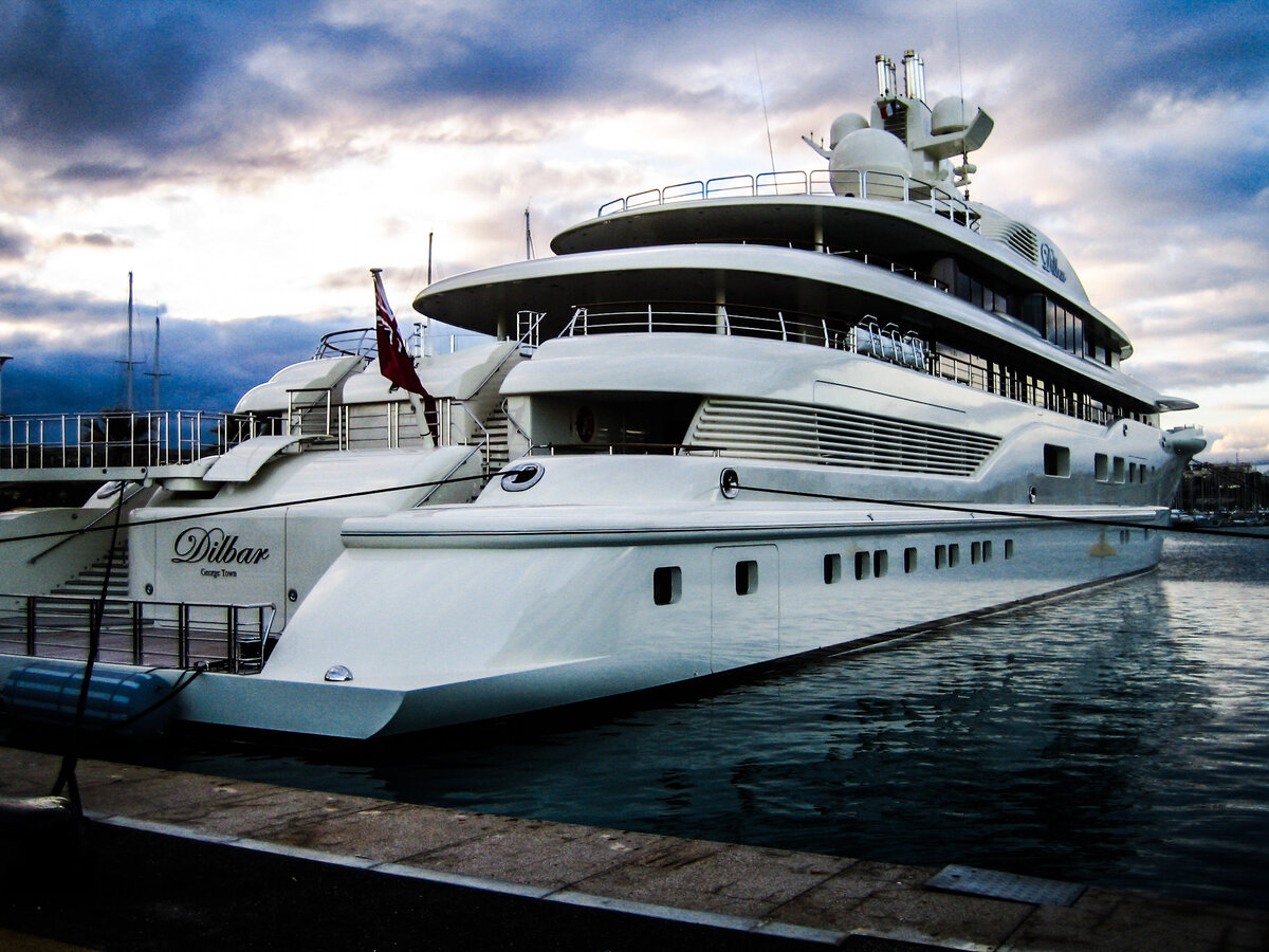 $ 256 000 000 Имя: Dilbar Владелец: Алишер Усманов Длина: 109,7 метра Особенности: Яхта названа в честь матери владельца. Принимает 21 гостя, которых обслуживают около 50 человек. Максимальная скорость – 21 узел. Судно весьма экологично: выхлопные газы очищаются угольными фильтрами, что было применено на Dilbar впервые в мире мегаяхт. Помимо двух вертолётов, несёт ряд тендеров и вообще всё, что нужно для занятий водными видами спорта: вейкборды, акваланги и прочее. Обладает обширным спортивным залом и необычайно роскошным обеденным залом. Внешний дизайн: Тим Хейвуд. Внутренний: Альберто Пинто. В чартер сдаётся очень редко, только личным знакомым владельца. Внешне весьма схожа с яхтой Pelorus, занимающей седьмую строку списка.


