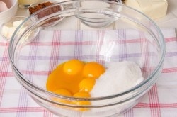 ШАГ 2:
Приготовьте бисквит. Сперва очень аккуратно разделите яйца на белки и желтки. К яичным желткам добавьте 100 г сахара.