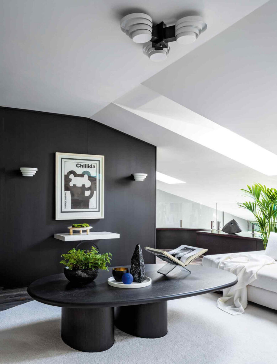 Фрагмент гостиной. Люстра и бра Olympus, Raak; журнальный столик по эскизам Марины Филипповой; консоль, Liaigre; на консоли и столе каменные аксессуары из Booroom Gallery; постер Эдуардо Чильиды.
