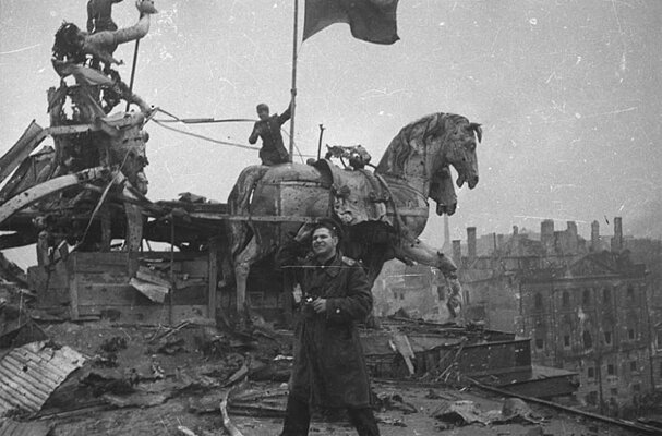 Красный флаг на Бранденбургских воротах.  На переднем плане сам Е. Халдей.  На фото один из красных флагов, привезенных Е. Халдеем из Москвы.