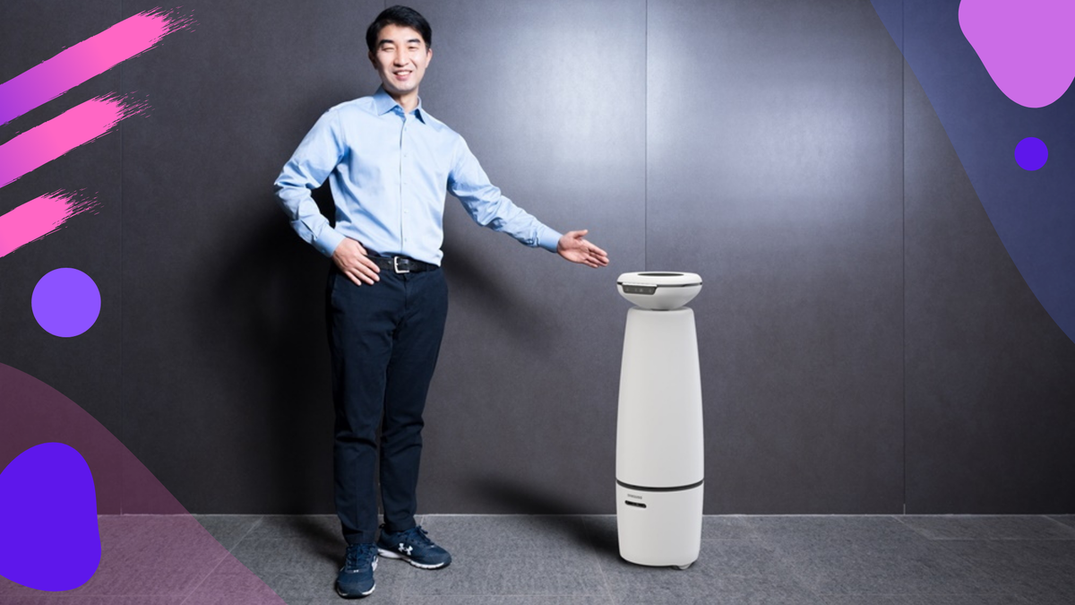 Junghoe Kim из исследовательского центра роботов Samsung стоит рядом с интерактивным роботом Samsung Bot i