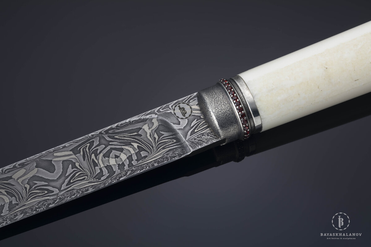 Автор: Жигжит Баясхаланов. Эксклюзивный бурятский традиционный нож "Пламя костра".
Материалы: Дамасская сталь, моржовый клык, бронза с гальваническим серебрением/белый металл, кожа ската, гранаты. Сайт автора: zhigzhit.com