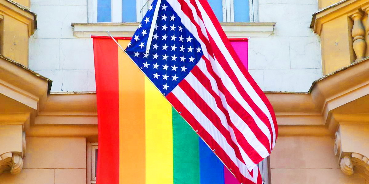 Флаг США на фоне радуги, а радуга на фоне посольства