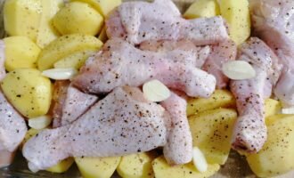 
Голени помыть. Картошку почистить, помыть, разрезать пополам. Чеснок почистить, разрезать пополам. Посолить, поперчить.
