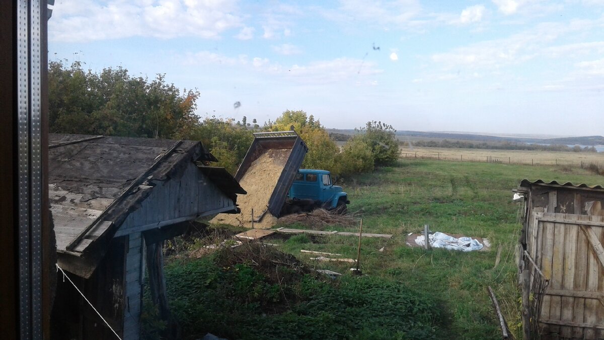 Смотрите на горизонт. Сараи мы снесли, машина выгружает песок для фундамента бани.