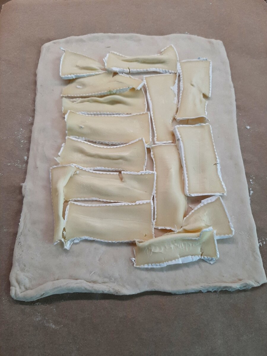 Раскладываем сыр на раскатанное тесто