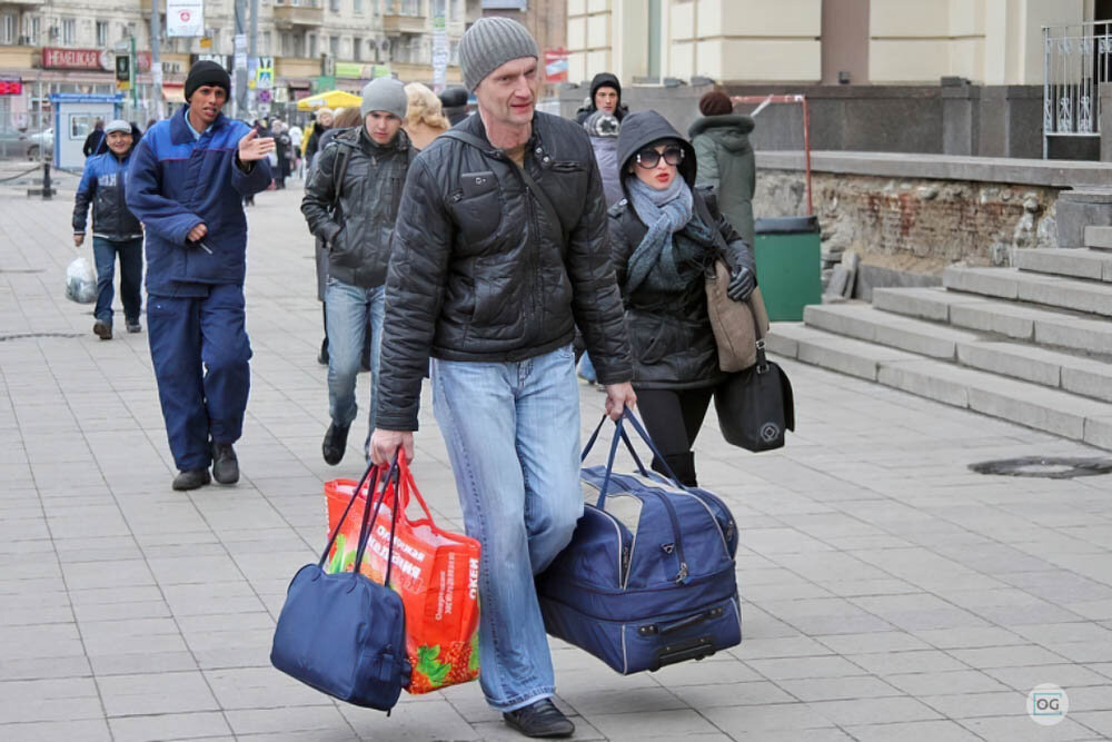 Уезжать ли в город. Мужчина несет сумку. Мужик с сумкой. Мужчина с тяжелыми сумками. Нести сумку.