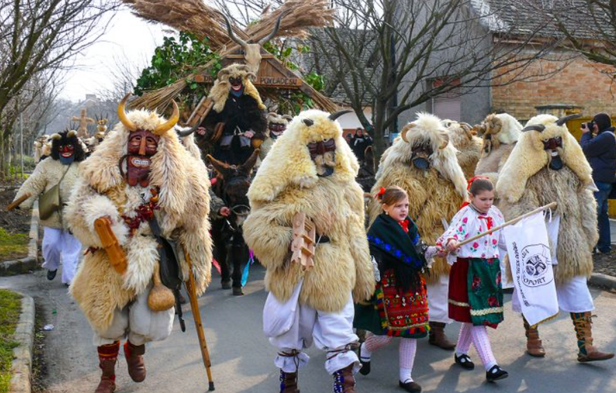Праздник прощания с зимой в Венгрии — Бушояраш (поход бушара). На картинке представлены бушо или бушары - персонажи в масках с большими зубами и огромными рогами, одетые в овечью шкуру. По разным легендам они помогли прогнать турок или зиму. В течение праздника бушары ходят по улицам, шумят, пугают зрителей, но в целом доброжелательны, например, могут погладить незнакомого человека по голове. 