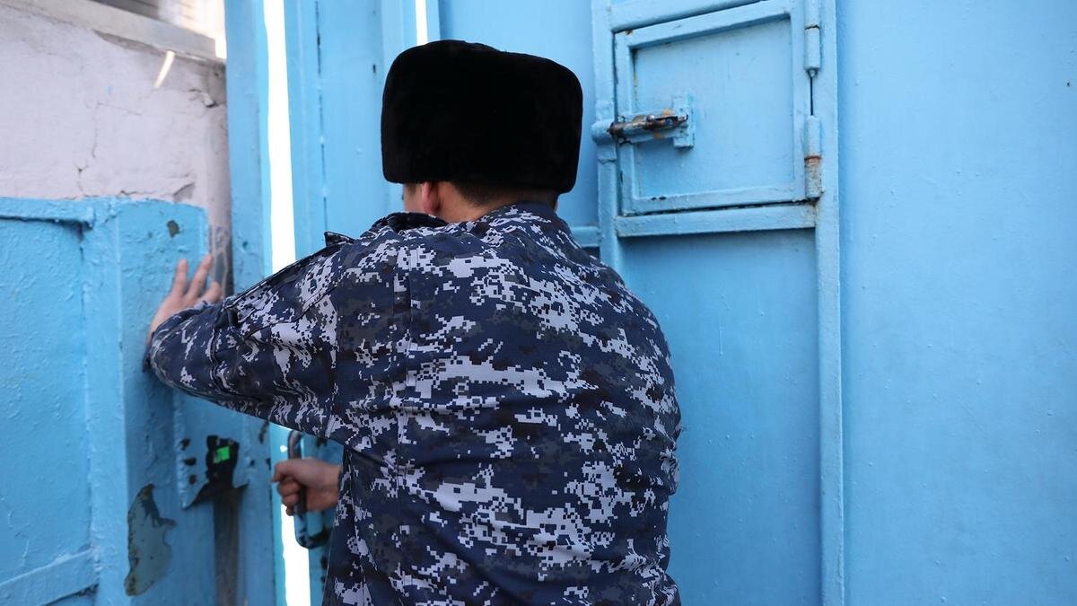    Сотрудник СИЗО закрывает дверь:NUR.KZ / Петр Карандашов