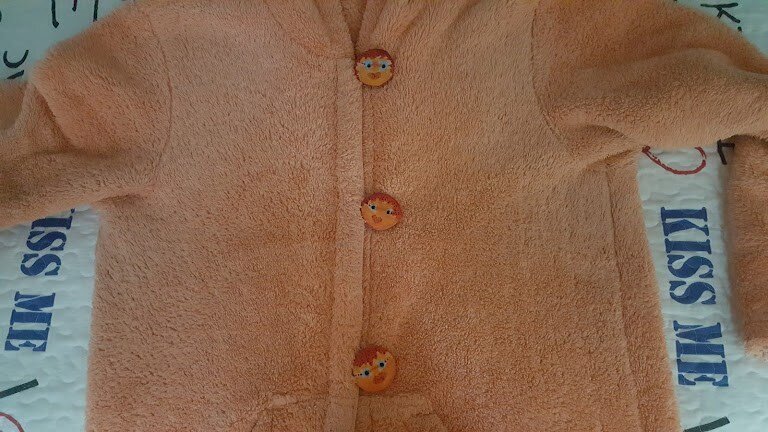 Большие деревянные пуговицы на мягкой курточке.