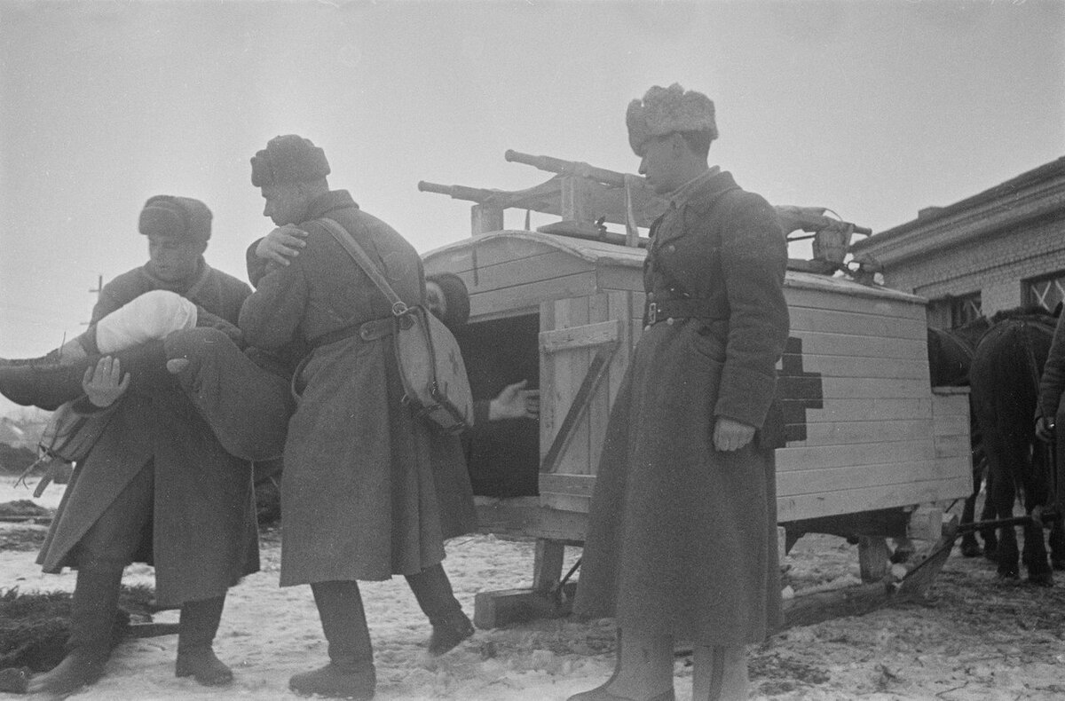 Советские санитары выгружают раненого красноармейца из санитарных саней.Автор: Семен Фридлянд. http://test.waralbum.ru/236956/
