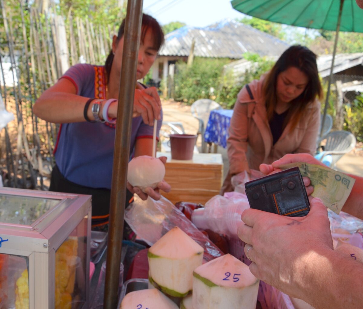 Это я покупаю небольшой белый кокос в Чианг Рае. Внизу фотографии видны обычные кокосы, с частично стесанной койрой по 25 бат. Но нужно же было попробовать и еще один сорт кокоса!)) Фото автора.