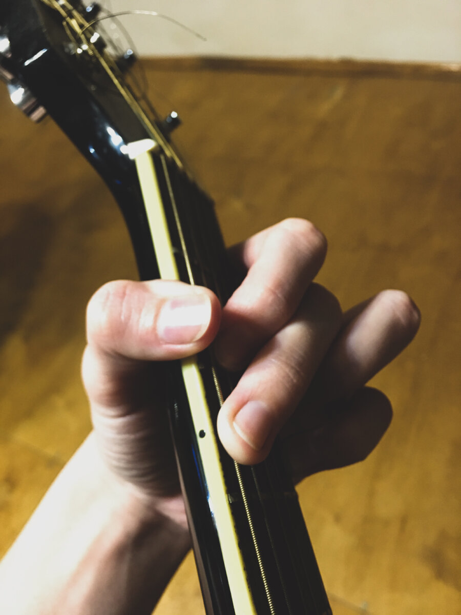 Неудобное расположение левой руки - большой палец загнут, кисть «висит» на грифе . На фото взят аккорд G, пальцы завалены, почти все открытые струны будут заглушены 