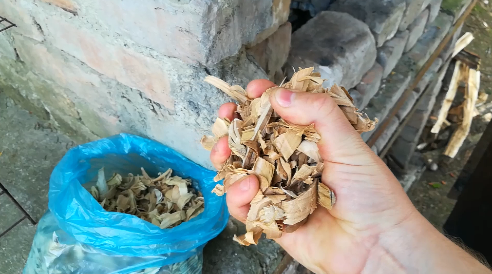 засыпаю 2 жмени щепы в коптильню 