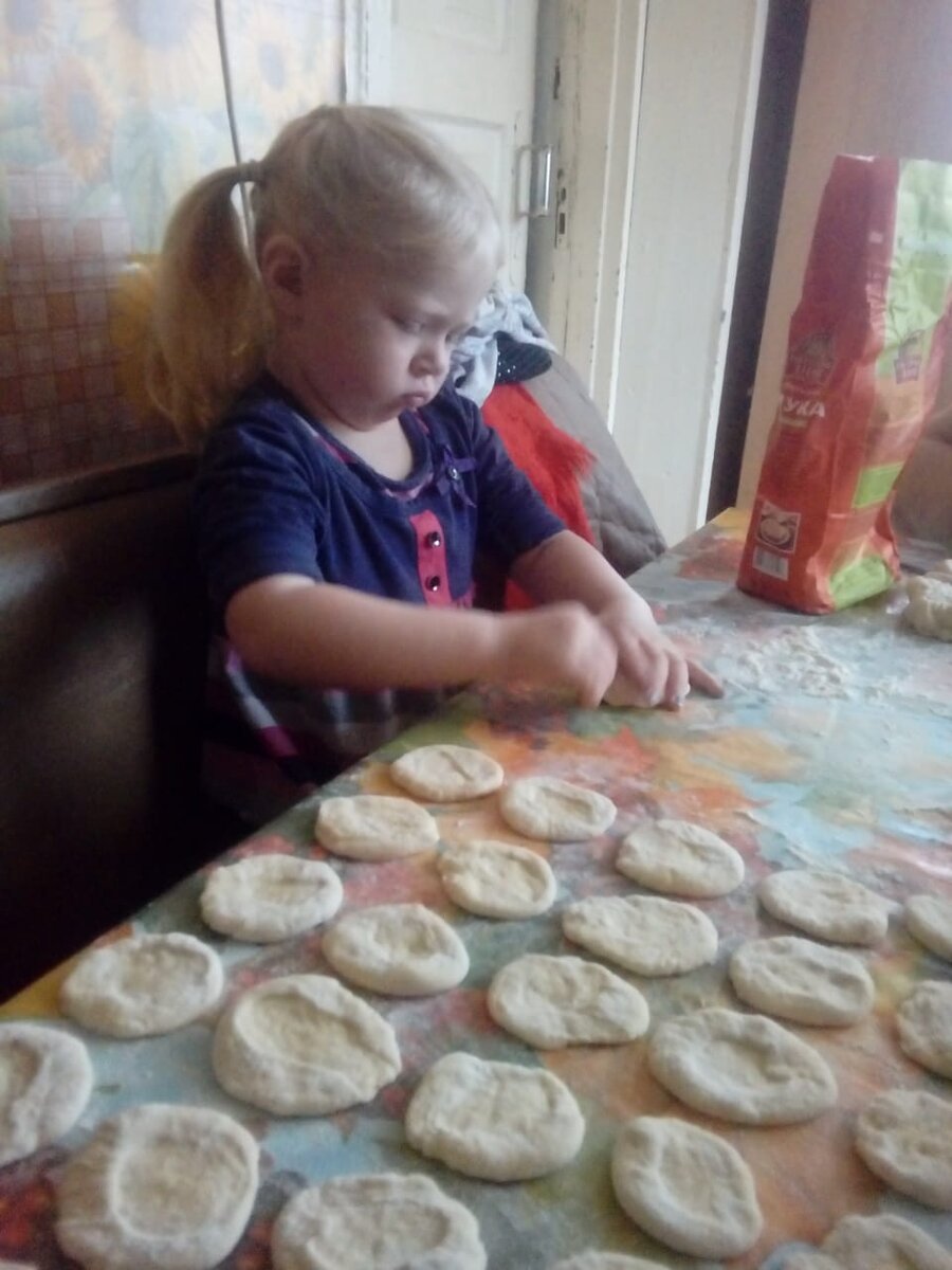 Внучка помогает лепить вареники. Это тесто первого варианта, без минералки. Видите - везде мука! Фото из личного архива.