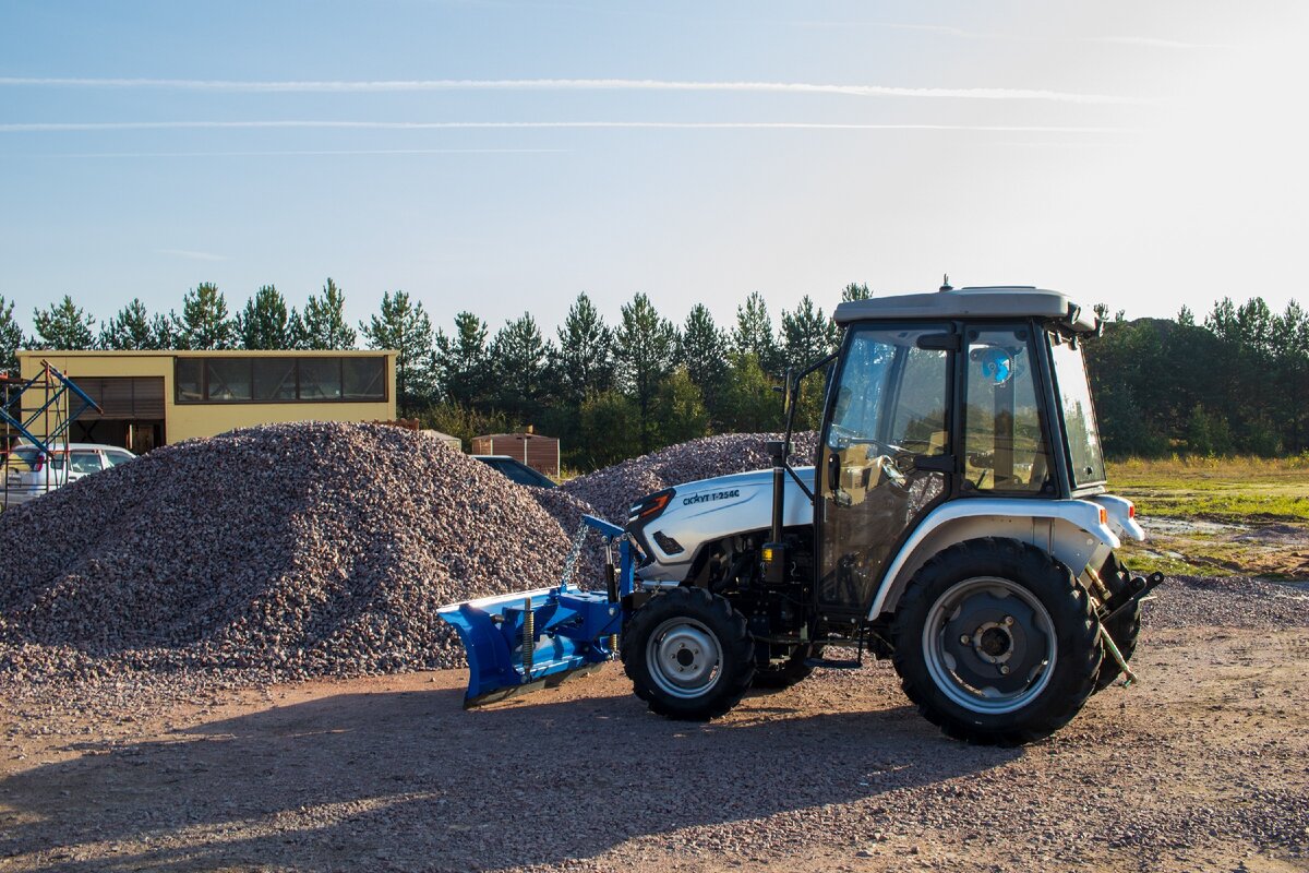 СКАУТ Т-254С убирает гравий при помощи отвала. 
