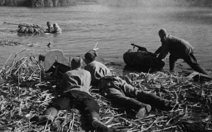 Советские бойцы с пулемётом у реки на переправе.