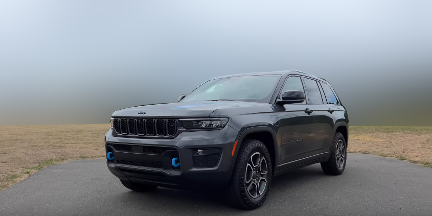 Дизайн передней и левой части кузова в комплектации Jeep Grand Cherokee 4xe Trailhawk 2022 года.