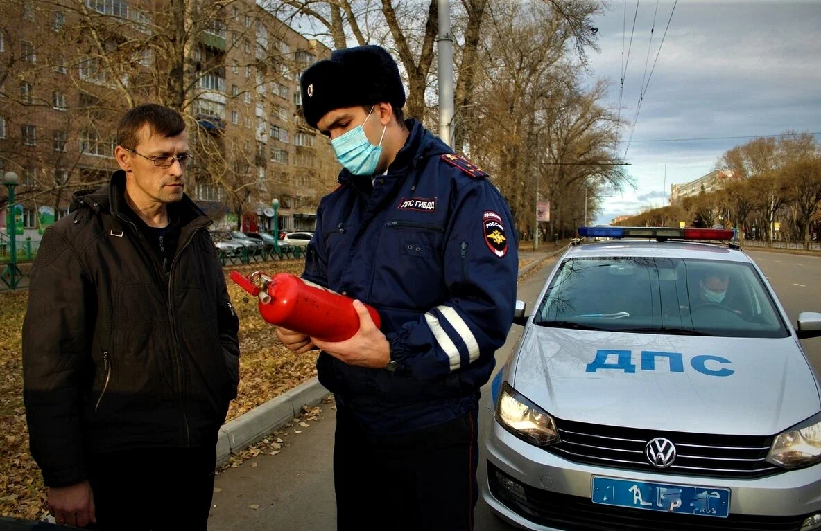 ГИБДД огнетушитель. Инспектор ДПС проверяет огнетушитель. Гаишник с огнетушителем. Работник ДПС.