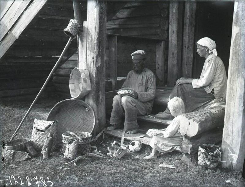 Крестьяне за плетением, тут и моток берестяных ленточек, и пестерь, и берестяной таз, и лапти