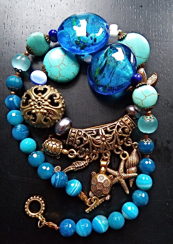 Ожерелье с крупными синими стеклянными бусинами. Подложка из фольги хорошо просматривается. Также в ожерелье есть тонированные агаты и кошачий глаз Фото из личного архива.