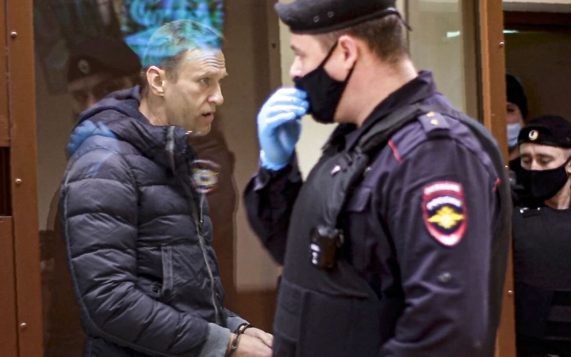 Лидер российской оппозиции Алексей Навальный в стеклянной клетке во время слушания обвинения в клевете в московском суде 12 февраля