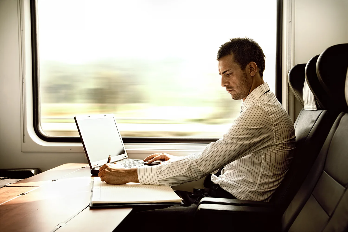 Завершение командировки. Бизнесмен в поезде. Бизнесмен с ноутбуком. Люди в поезде. Бизнесмен в поезде с ноутбуком.