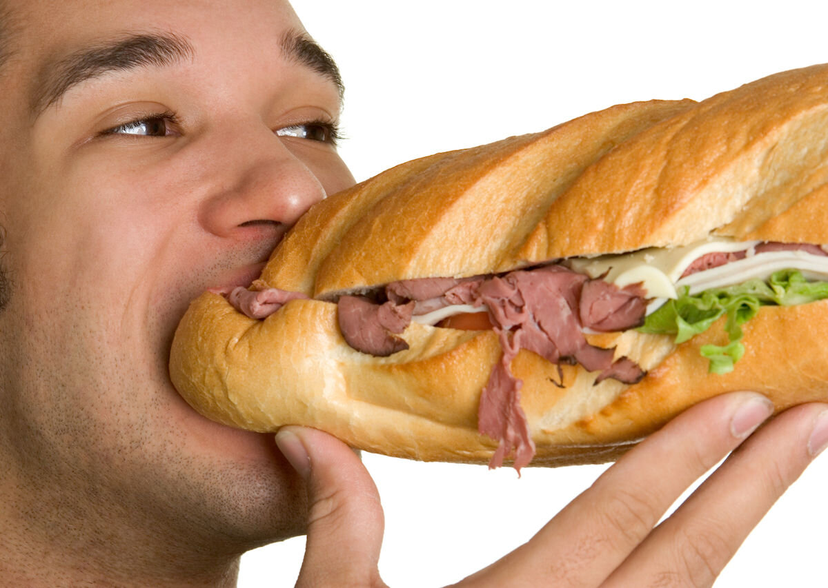 Человек ест сэндвич