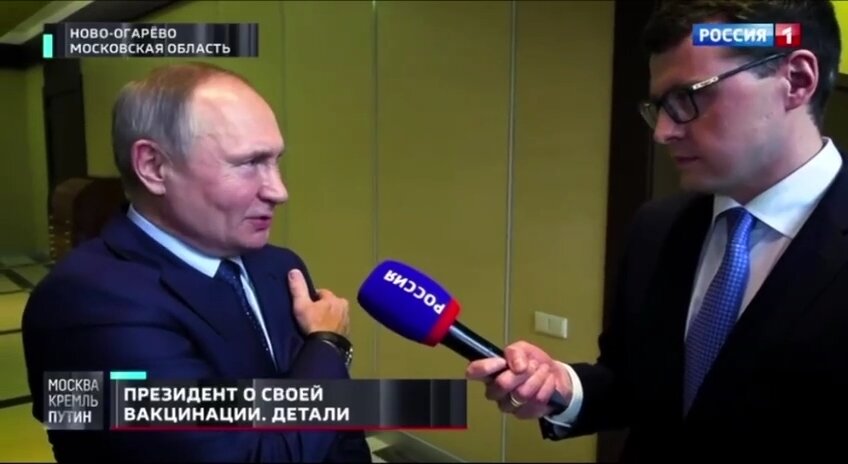 Путин показывает, куда ему сделали прививку. Источник: Youtube канал Россия 1.