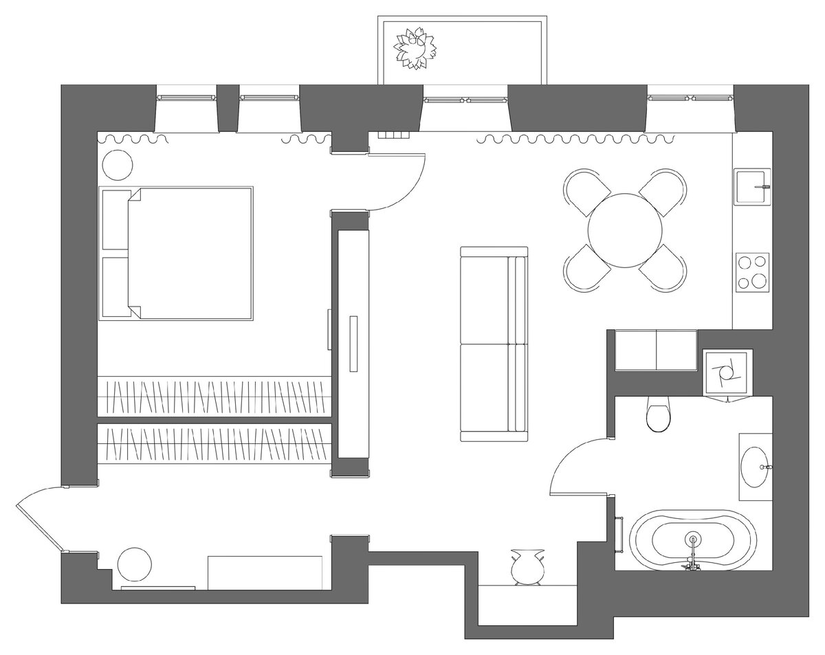 Типовую двухкомнатную квартиру с маленькой кухней и длинным коридором превратили в евродвушку: кухню объединили с гостиной и частью коридора. Спальню уменьшили, чтобы организовать хранение в прихожей, а раздельный санузел сделали совмещённым и немного увеличили за счёт коридора. 