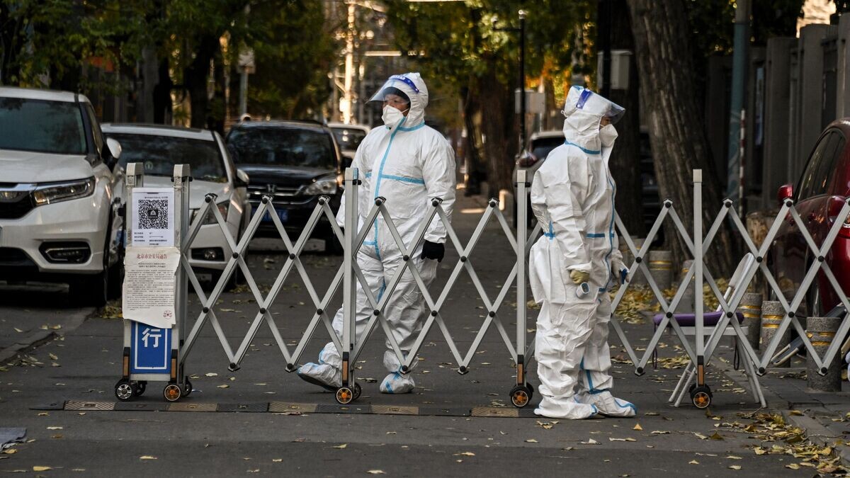    Сотрудники службы безопасности охраняют вход в жилой район в Пекине, закрытый из-за ограничений, связанных с коронавирусом© AFP 2022 / Noel Celis