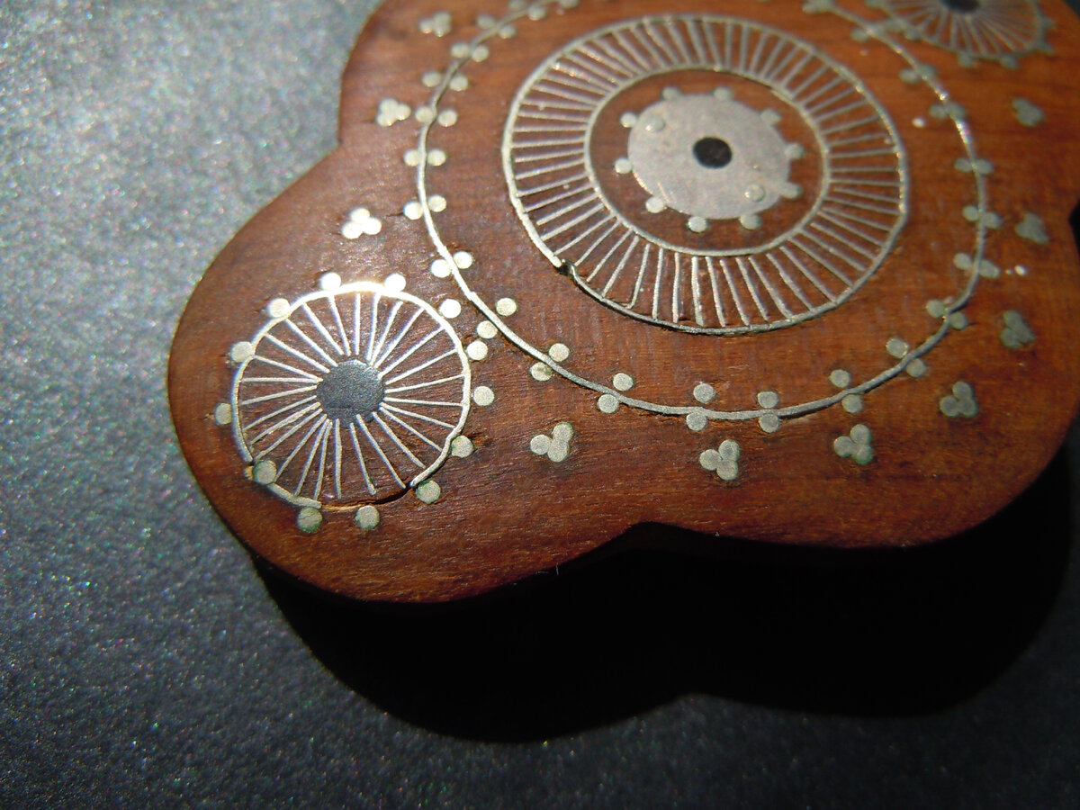 Фрагмент броши. Благодаря небольшим утратам хорошо видна насечка и проволока, "вбитая" в дерево.